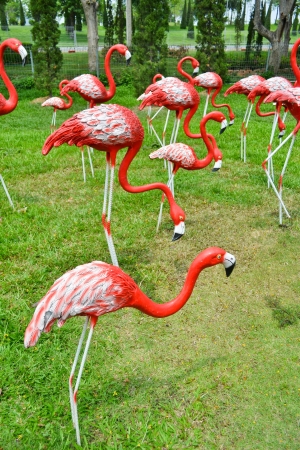 red flock egrets statue on green fieldの写真素材