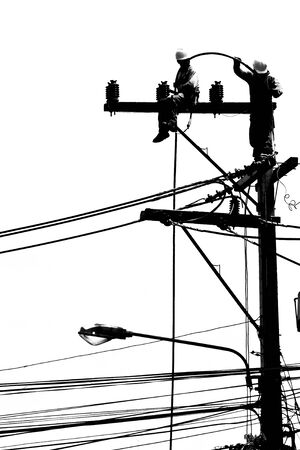silhouette electrician working on electricity postのeditorial素材