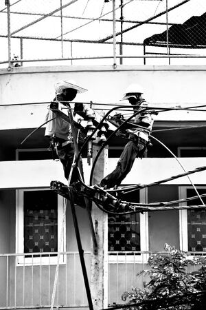 silhouette electrician working on electricity postのeditorial素材