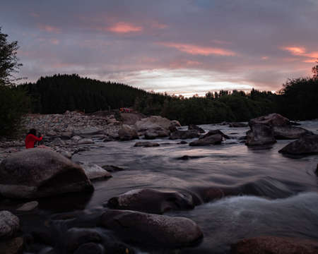 dusk on a river bank with many stones on a cloudy day