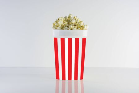 Popcorn box isolated on clean natural background. Good for watching cinema and movies. Delicious but unhealty nutrition.の写真素材