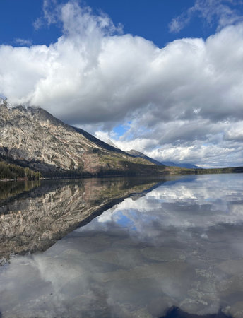 Reflection of mountains and clouds in the Grand Tetons.