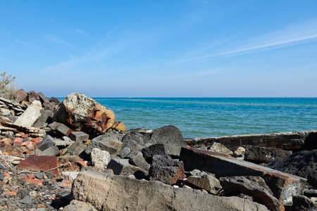 Litter on the beach against a blurred background of pristine blue  ocean and sky