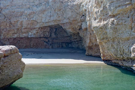 Deserted private cove with calm ocean against a backdrop of cliffsの写真素材