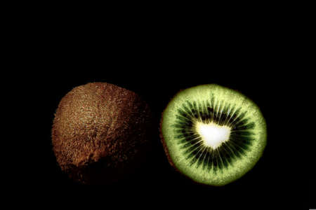 Two halves of a kiwi fruit against a black backgroundの写真素材