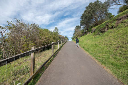 girl walking up a road on a hill sideの写真素材