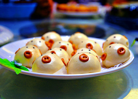 China - Funny steamed dumplings with eyes on a white plateの写真素材
