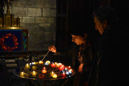 Lady lighting a candle in a catholic church, Paris, Franceのeditorial素材