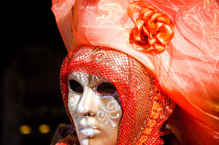 Venice Carnival - women with orange dress and white maskの写真素材