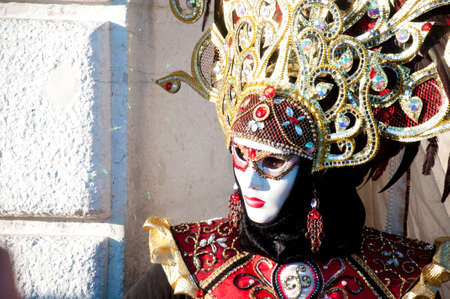 Venice Carnival - woman with gold and red dress and white maskの写真素材