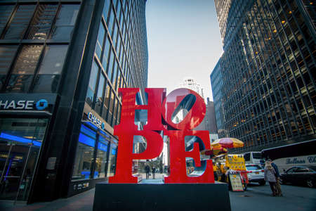 New York City, New York / United States -Oct 15 2016: HOPE Sculpture By Robert Indiana corner of 7th and 53rd in New York City. Wide angle view with skyscraper on both sides. Chase store frontのeditorial素材