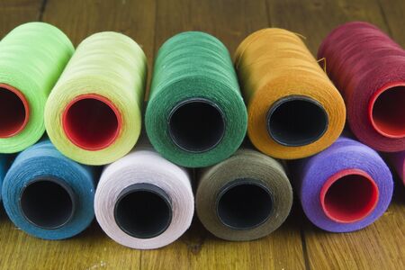 bobbins colorful threads on wooden table