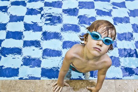 red hair child in pool with goggles onの写真素材