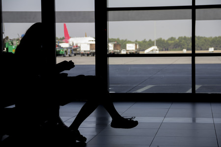 woman silhouette waiting for plane at airportの写真素材