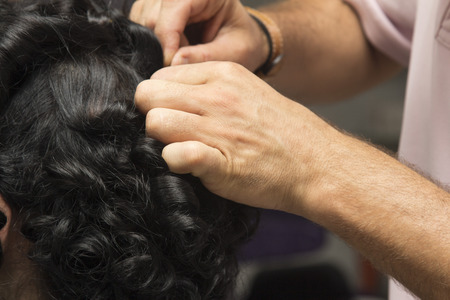 black curly hair girl at hairdresserの写真素材