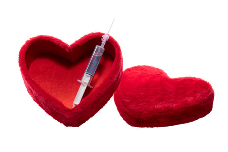 Box in the shape of a heart with a vaccination needle on white background.の写真素材