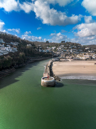 Aerial drone photograph showing Banjo Pier, Looe Harbour, sandy beach and seaside town of Looe in...