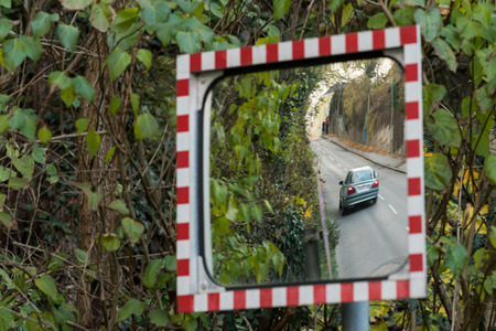 Reflection of a driving car in a mirror, green leavesの写真素材