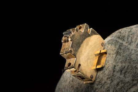 Closeup of a small golden model of a circuit breaker mounted to a polished stoneの写真素材