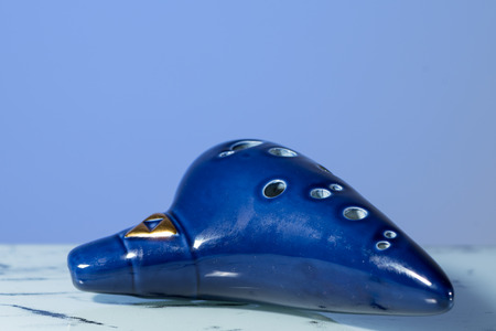 A blue ocarina in front of blue background, reflective undergroundの写真素材