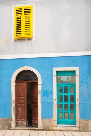 Colorful facade, blue wall, yellow shutter in the historic center of Cres, Croatiaの写真素材