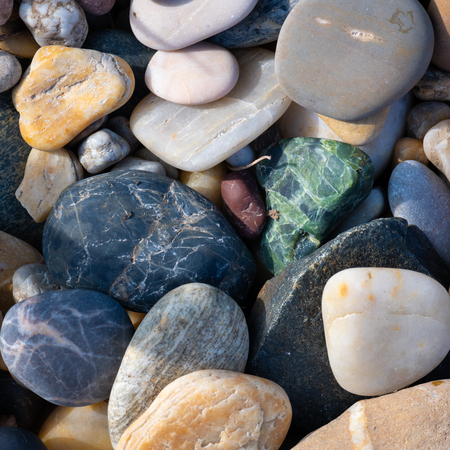 A group of various colorful small stones direct sunlightの写真素材