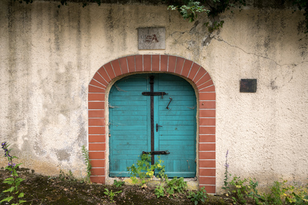 Entrance of a traditional wine cellar in Lower Austria, door and ventilation hole, initials of the first owner above the doorの写真素材