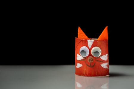 Closeup of a red cat made of toilet paper roll by a childの写真素材