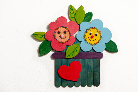 Colorful figure of flowers in a garden made of wood by a child on white backgroundの写真素材