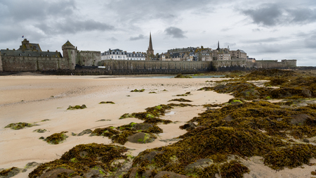 Old town of Saint-Malo (Brittany, France) at low tide on a cloudy day in summerの写真素材