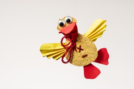 A colorful flying duck made of paper by a child on whiteの写真素材