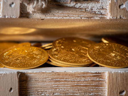 Shiny gold coins (Austrian ducats) in a small wooden treasure boxの写真素材