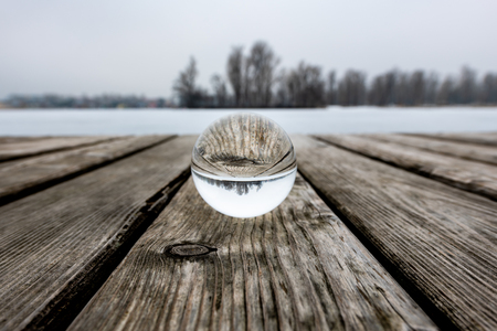 Glass sphere on a public bathing place in winter, frozen water (Vienna, Austria)の写真素材