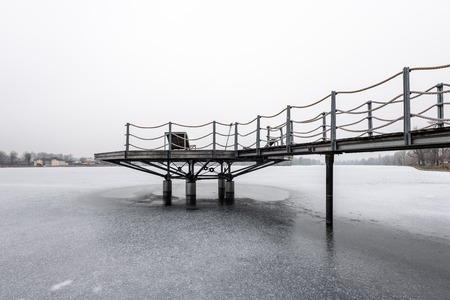 Public bathing place in winter, frozen water, lounger made of wood (Vienna, Austria)の写真素材