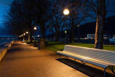 White park benches in a park (sunset molo) in Bregenz (Asutria) after sunset in early springtimeの写真素材