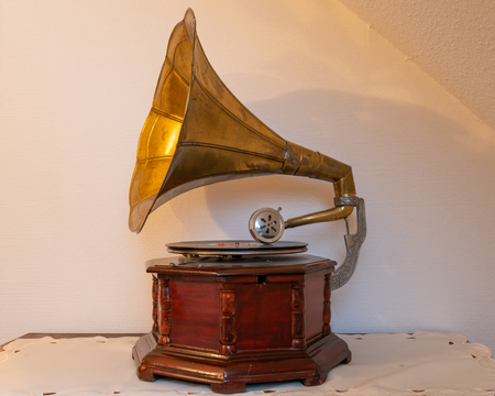 Closeup of an old gramophone standing on a table, white wallの写真素材