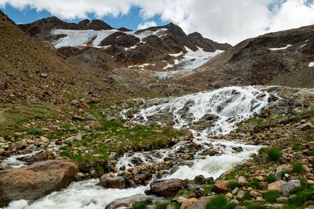 Small river in Martell valley in South Tyrol (Italy) on a partly cloudy day in summerの写真素材