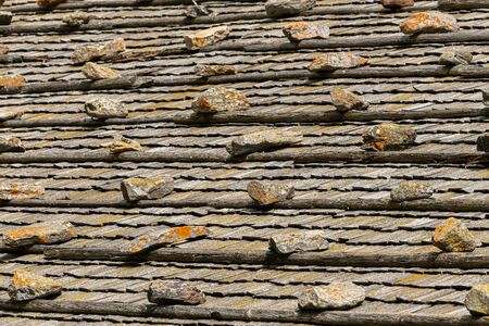 Abstract of an old wooden roof of a farmer house with small rocks (South Tyrol, Italy)の写真素材