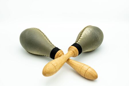 Closeup of a pair of rawhide maracas lying on a white underground