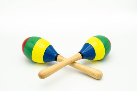 Closeup of a pair of colorful maracas lying on a white underground