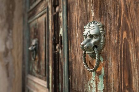 Closeup of a bronze door handle on a brown door in Venice (Italy)の写真素材
