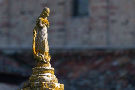 Small statue of a woman made of stone, in front of church of Santa Fosca (Torcello, Italy)の写真素材