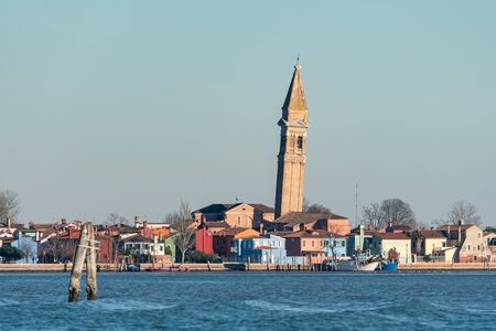 The leaning bell tower of Burano (Venice, Italy) on a sunny day in winterの写真素材