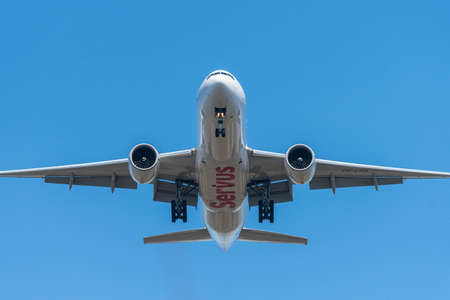 Vienna, Austria - April 4, 2020: Airplane on landing approach on a sunny day in spring, blue sky,...