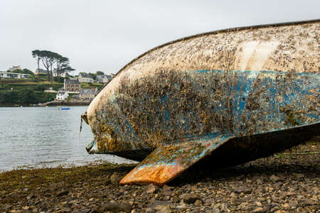 Dirty bottom of old sailing yacht lying on ground, low tide, atlantic coast in Brittany (France)の写真素材