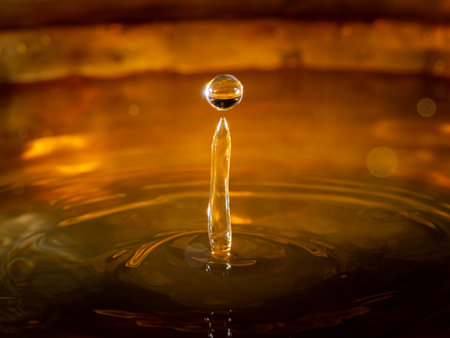 Closeup of a water droplets hitting the surface, dark, bronze background
