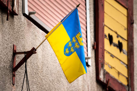 Small flag of Lower Austria on a wall of an old house, cloudy day in springtimeの写真素材