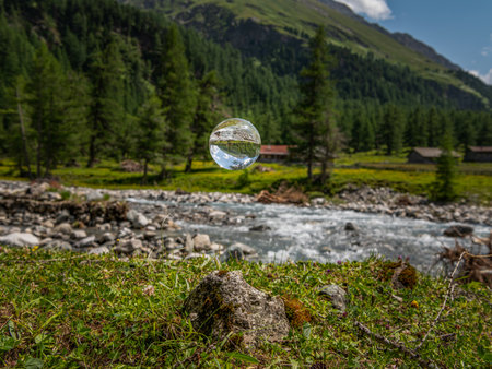 Glass sphere floating, river in Austrian alps, Dorfer Tal in National Park Hohe Tauern, sunny day in summerの写真素材