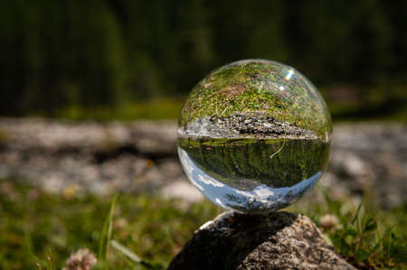 Glass sphere lying on a rock, river in Austrian alps, Dorfer Tal in National Park Hohe Tauern, sunny day in summerの写真素材