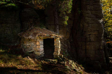 Small stone hut in the middle of a forest, sunny day in autumnの写真素材